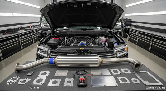 2017-2023 GM Chevy Duramax L5P 6.6L engine with EGR delete block-off plates and 5-inch stainless steel DPF delete downpipe laid out on a professional diesel shop workbench