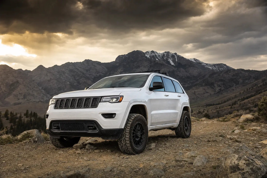 Jeep Grand Cherokee EcoDiesel on off-road trail with rocky terrain and mountain backdrop